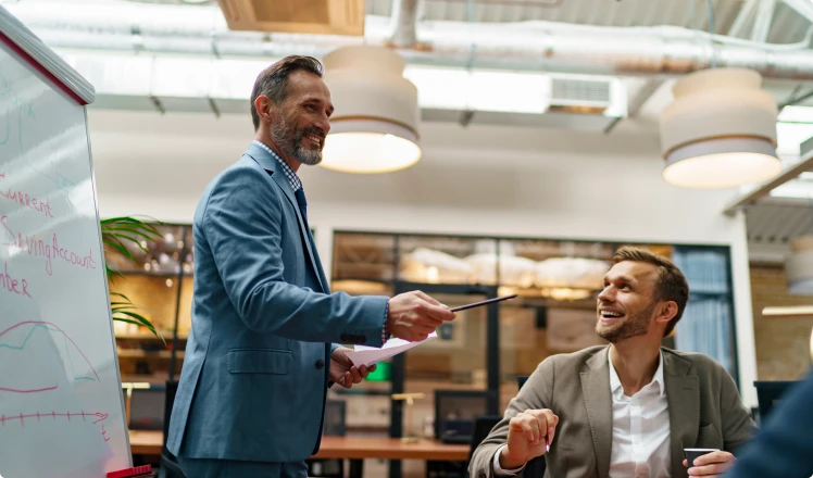 Deux professionnels en réunion dans un bureau, illustrant l’accompagnement et le conseil pour la création d’entreprise.