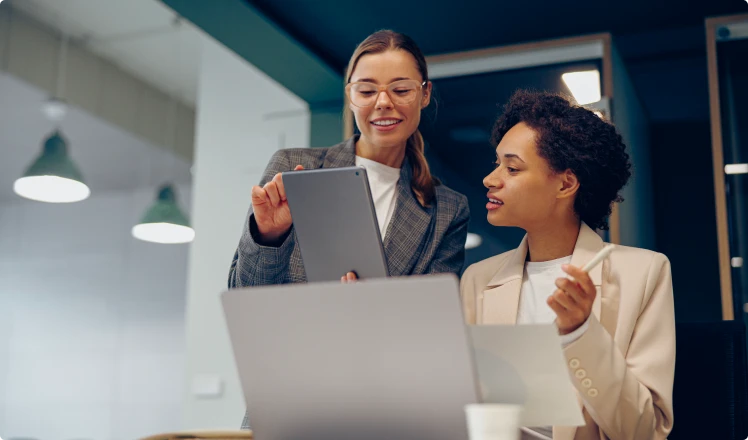 Discussion professionnelle autour de documents, illustrant l’accompagnement en comptabilité, audit et conseil.
